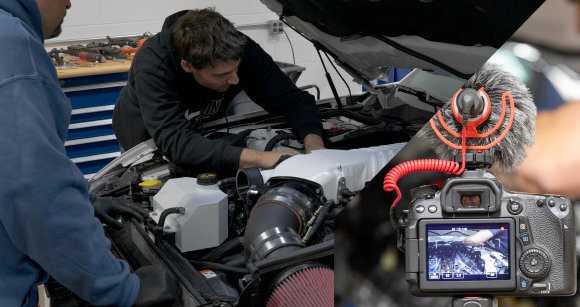 Creator filming an engine bay install with a camera and microphone